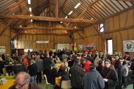 La foule se presse autour des stands dans la grange La foule se presse autour des stands dans la grange